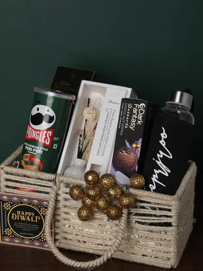 This jute-handled basket is packed with snacks and useful items. It includes Pringles, a personalized bottle, a reed diffuser, and chocolates, making it a great all-rounder gift.