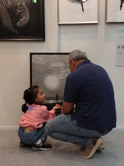 A heartwarming moment as a father and daughter share a conversation while looking at my art. This is the connection I hope my work inspires.