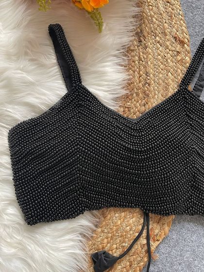 A close-up of the intricate pearl work on the black spaghetti blouse.