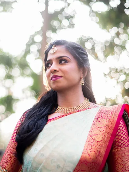 An artistic shot of a bride, her features beautifully lit, showcasing a bold lip color.