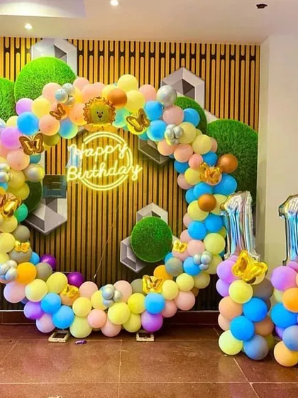 A colorful and cheerful 11th birthday celebration. This circular balloon arch uses a rainbow of pastel colors, with a neon sign and number balloons indicating the age.