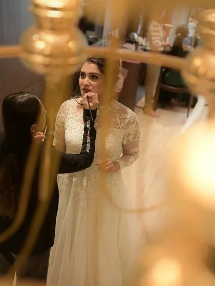 An artistic shot of me giving the bride her final touch-ups. It's all about perfection on the big day.