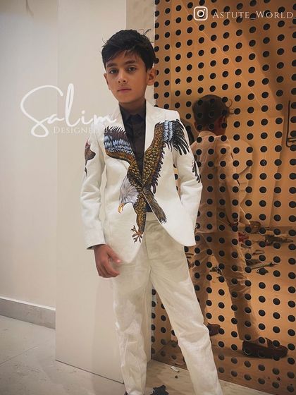 A young client wearing a custom white suit with a hand-painted eagle spreading its wings across the jacket. This is a great example of creating a powerful, matching look for a child.