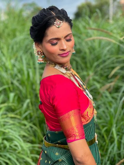 A side profile showing the details of her makeup and traditional jewelry.