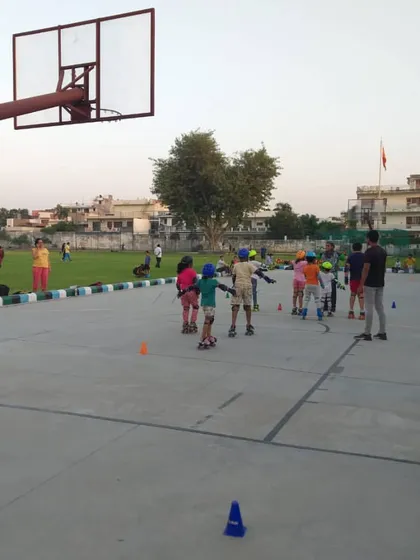 A coach guides a group of young children during a skating lesson. Personal attention helps beginners gain confidence on their skates quickly.