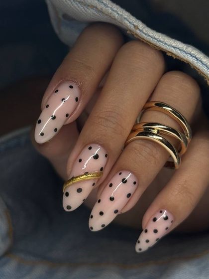 A full view of the polka dot manicure, showing how the gold accents are placed on different nails for a balanced and artistic effect.