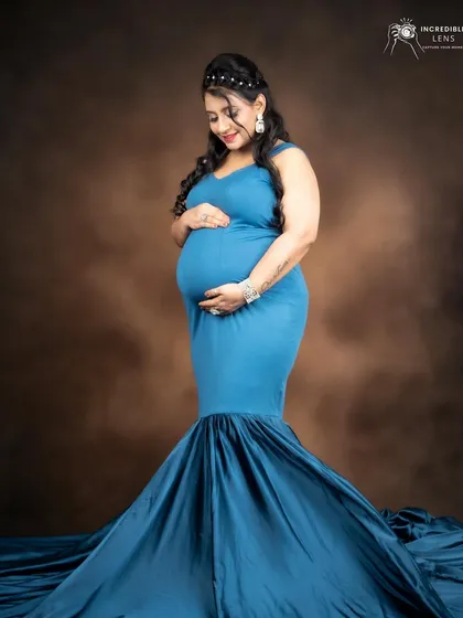 A stunning shot of the mom-to-be in a flowing blue gown. The makeup is elegant and timeless, perfect for capturing this precious moment.