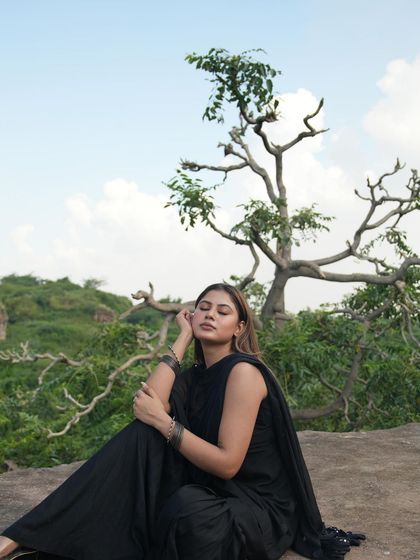 A serene, full-length shot of the model with her eyes closed, enjoying the peaceful natural surroundings.