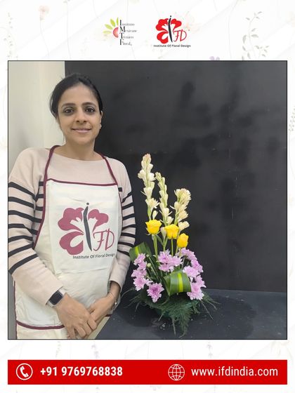 It all starts here. A student from our introductory class smiles with her completed first assignment, a key step in building the confidence needed for more complex floral work.