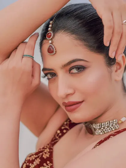 A close-up portrait from the beach shoot, focusing on the model's intense gaze and the beautiful details of her modern ethnic wear.