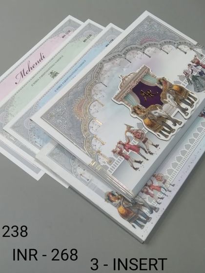 A regal invitation featuring a 'doli' or palanquin, carried in a procession. The silver foil and intricate details give this card a luxurious and traditional feel.