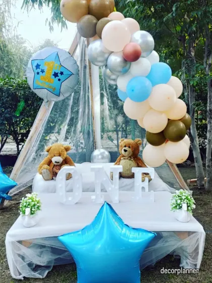 This simple yet elegant first birthday setup features a cabana tent with teddy bears and a 'ONE' marquee sign. It's a perfect, gentle theme for an outdoor photoshoot or a small celebration.