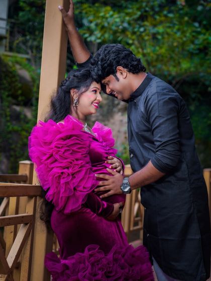 An intimate couple's portrait on a wooden bridge. The natural setting and their close, loving pose create a romantic and peaceful image.