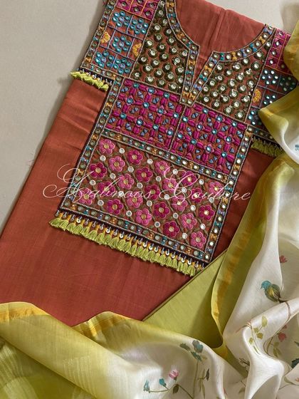 A top-down view of the rust kurta, showcasing the intricate and colorful hand-embroidery that makes this piece unique.