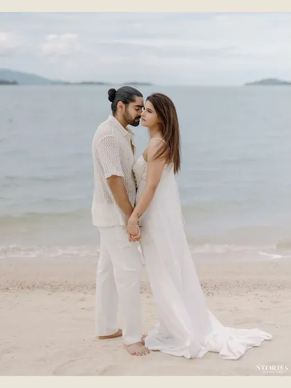 A romantic, full-length portrait of the couple by the water's edge.