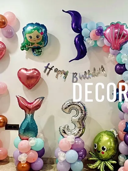 A simple yet charming mermaid-themed birthday decoration for a 3rd birthday. The setup uses various foil balloons, including a mermaid tail, octopus, and hearts, to create an underwater scene.