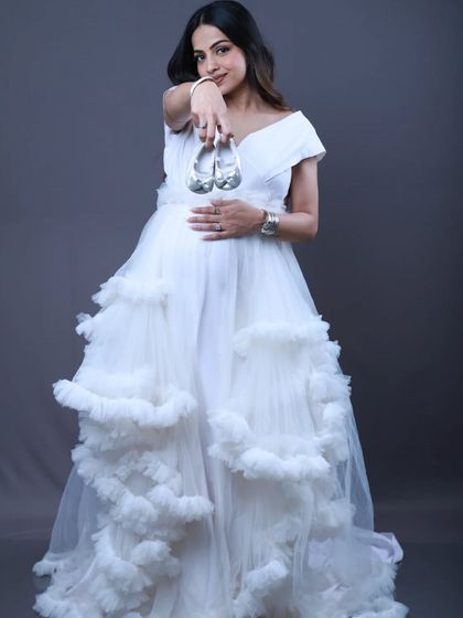 Get two looks in one with this white convertible gown, perfect for maternity shoots. You can have a sleek body-fit style or a dramatic ruffle look, all in one outfit.