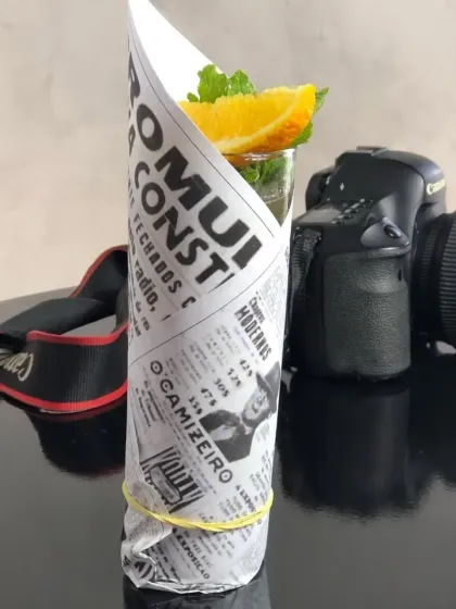 A creative and low-cost presentation idea. This drink is wrapped in newspaper print, giving it a rustic and unique look that stands out.