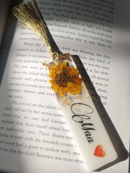 I created this 4-inch bookmark by preserving a beautiful dried sunflower. I also added the name 'Aliya', making it a personalized and cheerful accessory for any reader.