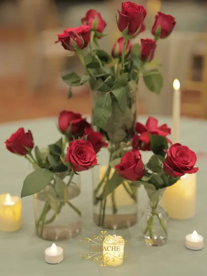 A collection of red roses in glass vases, used as a simple but beautiful centerpiece.