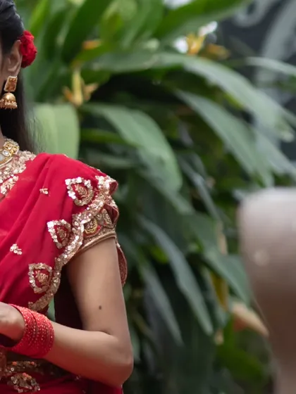 Our muse in a striking red ensemble, featuring a blouse with delicate zardosi work on the sleeves. A look that is both powerful and graceful.