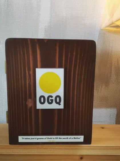 The front of the closed shadow box, featuring the OGQ logo and a quote. The rich, dark wood stain gives it a classic and respectful finish.