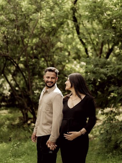 A lovely portrait of the couple walking through a sun-dappled forest, holding hands and sharing a look of love.