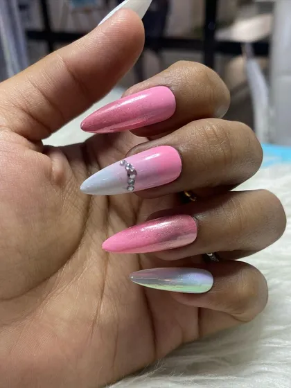 This almond-shaped press-on set is ready for purchase. It features a pink and white ombre design with chrome effects and a delicate rhinestone accent on the ring finger.
