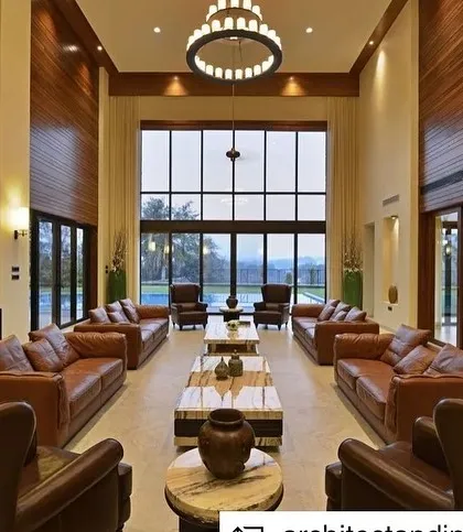 This double-height living room in a Khandala weekend home was designed to be a grand yet intimate space for family gatherings. The large windows frame the picturesque valley views, seamlessly blending the indoors with the outdoors and creating an atmosphere of expansive tranquility.