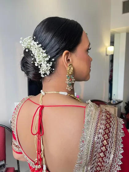 A side view of the soft twisted bun, showcasing the texture and the placement of the baby's breath for a fuller, more intricate appearance.