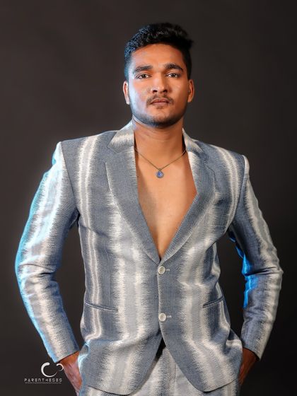 A confident, straight-on portrait. The open jacket and direct gaze create a look that is both bold and approachable, showcasing modern menswear style.