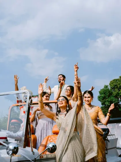 The bride and her squad making a grand entrance in a vintage car in Mahabaleshwar. A moment of pure joy and celebration against a brilliant blue sky.