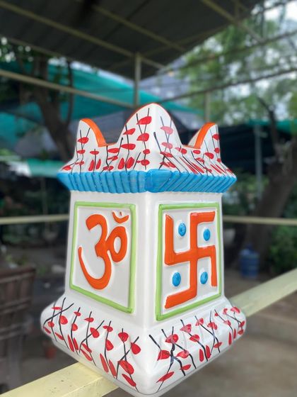 This is our special ceramic Tulsi pot, featuring hand-painted Om and Swastika symbols. It's a beautiful and auspicious choice for your holy basil plant.