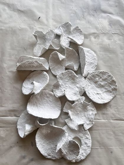 There is beauty in the breakdown. These are the raw, imperfectly folded pieces of upcycled paper before they are assembled, celebrating the cracks and the chaos.