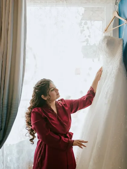 A quiet moment with her dress. The anticipation and excitement of the day are captured in this beautiful pre-wedding shot.