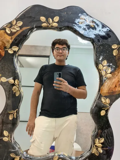 A quick selfie in one of my custom resin mirrors. The frame is a free-form shape with a black and gold leaf design, showing how versatile resin can be for creating unique decor.
