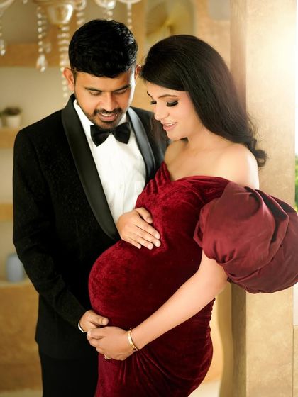 A classic, elegant portrait of the couple, with the father-to-be lovingly holding the baby bump.
