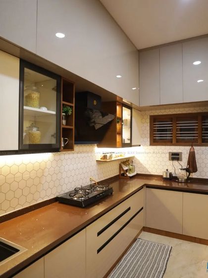 A close-up of the cooking area in this modular kitchen, showing the hob, chimney, and easy-to-clean backsplash.