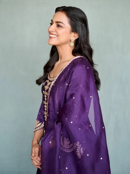 Shraddha Srinath looks radiant in this deep purple salwar suit for her movie promotions. The gold embroidery provides a rich contrast, making it a regal and elegant look for any formal occasion.