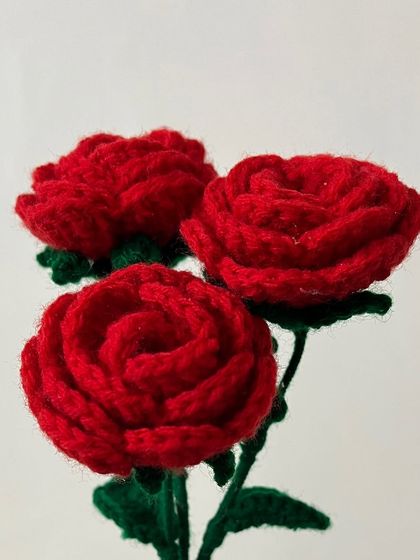 A close-up shot of my crochet red roses, highlighting the spiral pattern that gives them a realistic, layered look.