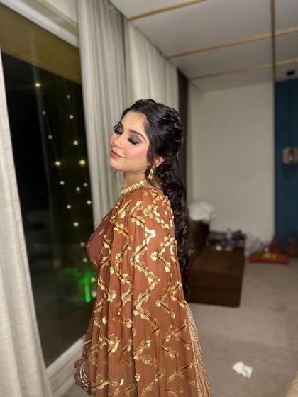 A classic Sangeet look with a smokey eye and soft curls. The warm, shimmering tones of her outfit are reflected in the makeup for a cohesive and glamorous feel.