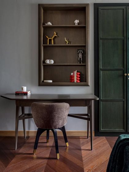 This study corner in the Aalay home is a perfect example of creating personal space within a family residence. The deep green wardrobe, rich wooden desk, and herringbone flooring come together to craft a quiet, sophisticated nook for work or reflection.