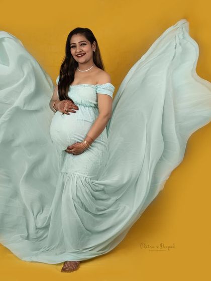 The beauty of a fabric toss. The mint green gown flows like wings against the bright yellow background, creating a dynamic and joyful image.