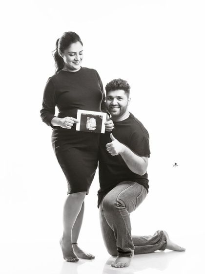 A joyful black and white portrait with the dad-to-be giving a thumbs-up next to the sonogram. This shot perfectly captures the pride and excitement of becoming a parent.