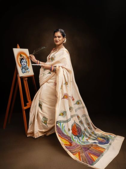 This artistic maternity portrait shows a mother-to-be painting an image of Little Krishna. It’s a powerful and creative concept that connects her own journey of creation with a divine theme. The hand-painted detail on her saree adds another layer of artistry to the photograph.