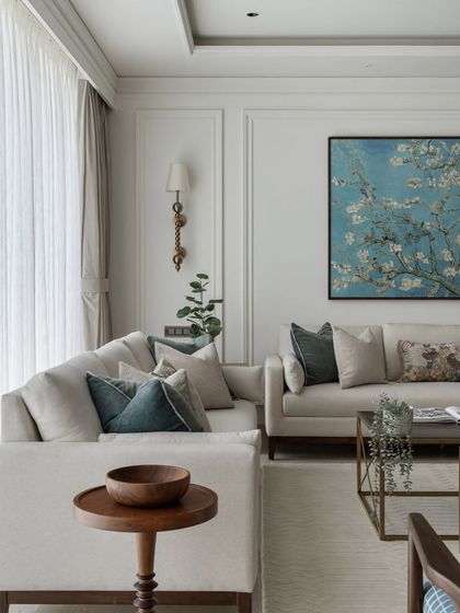 We love mixing textures and styles. Here, a soft, neutral sofa is accented with a striking blue floral artwork and a wooden side table, creating a corner that feels both calm and visually interesting.