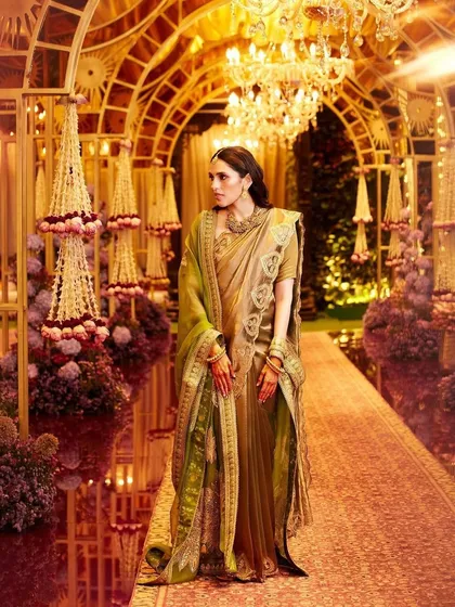 A full, regal shot of the Masaba saree against a grand, festive backdrop. The way the light hits the gold fabric is just stunning.