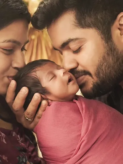 The gentlest of kisses for their newborn. This close-up shot highlights the deep love and affection in a new family.