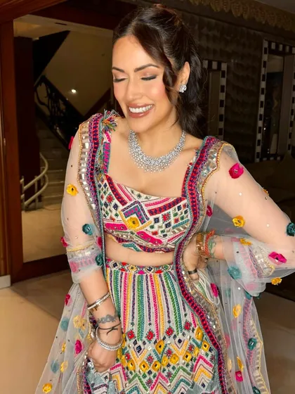 A joyful smile from this stunning client. The half-up ponytail is a versatile style that works beautifully for a fun event like a Sangeet or Mehendi.