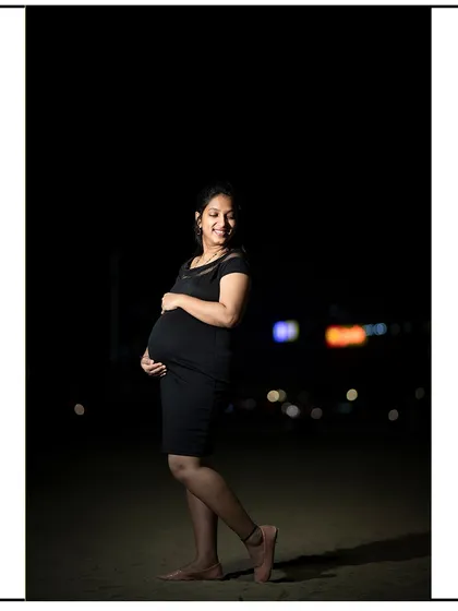 A simple and elegant solo portrait at night, with a soft focus on the mom-to-be.
